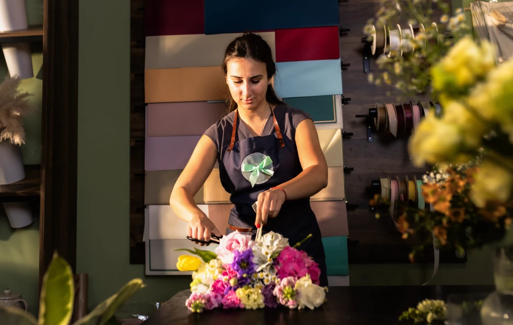 young-woman-working-in-her-flower-shop-making-bouqet