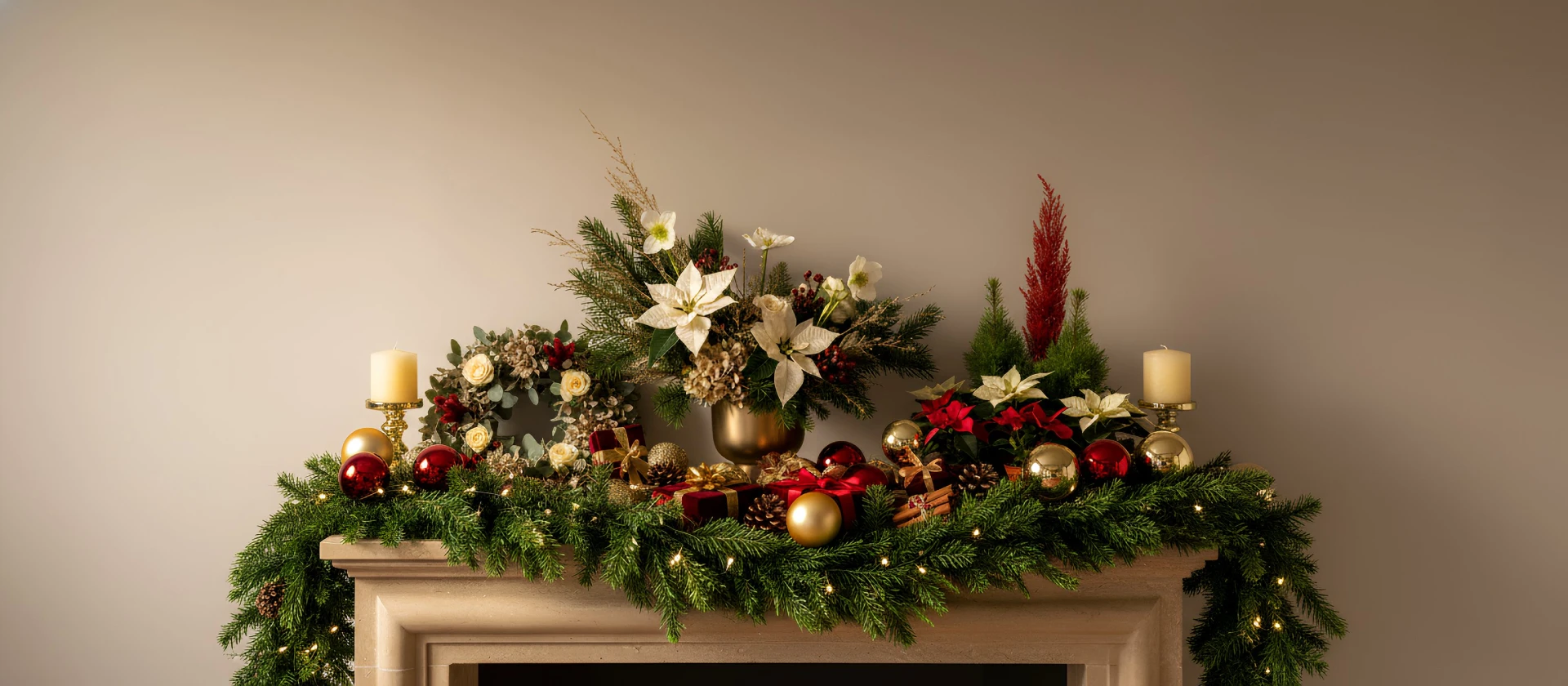 Decoración navideña elegante con guirnalda verde, velas y flores sobre una repisa.